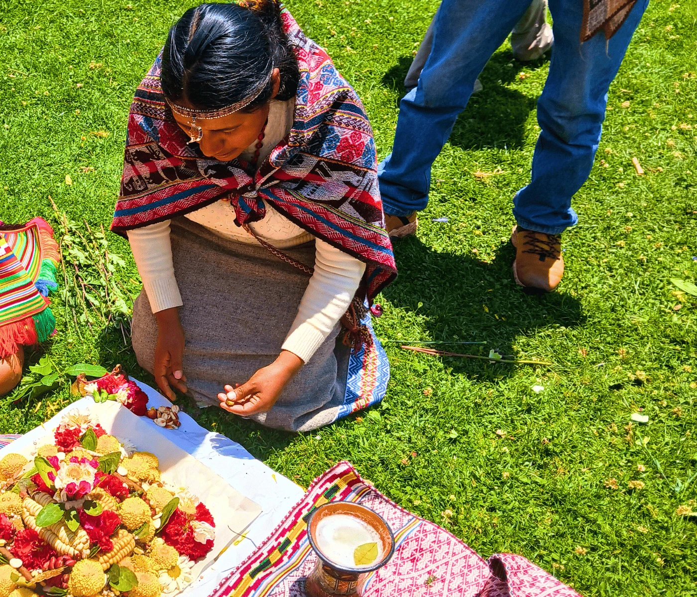Andean woman preparing offering with corn and flowers - Ayahuasca retreat Cusco, Peru